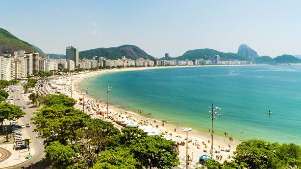 A coastal cityscape with a beach, high-rise buildings, and a prominent mountain. - Fairmont Rio de Janeiro Copacabana (Rio de Janeiro)