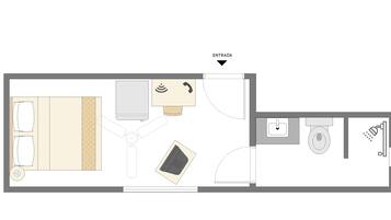 A hotel room layout with a bed, desk, chair, and a small bathroom area including a sink and toilet.