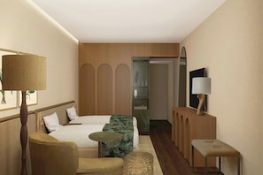 A hotel room with a bed, a chair, a small table, a lamp, and a mirror.