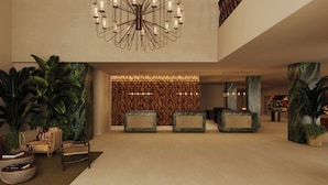 A spacious lobby with a modern chandelier, reception desk, and large potted plants. - Tropical Hotel da Amazonia, a Tribute Portfolio Hotel (Manaus)