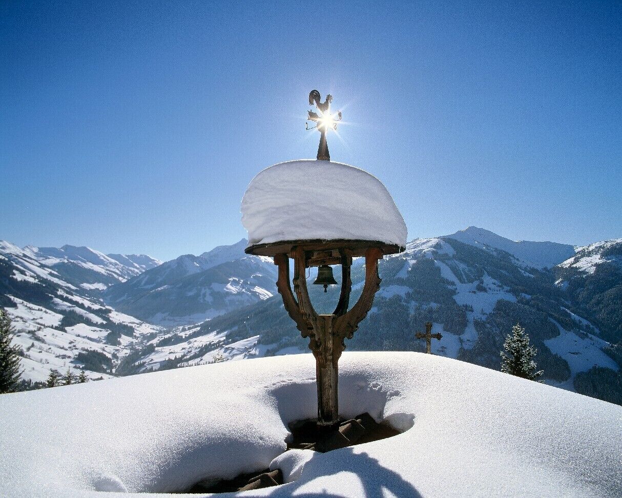 Eine verschneite Berglandschaft mit einem Glockenturm.