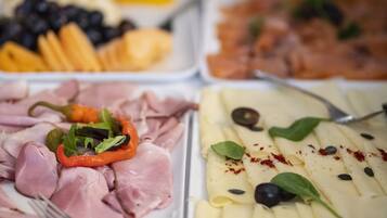 A buffet with various food items including meats, cheeses, and vegetables.