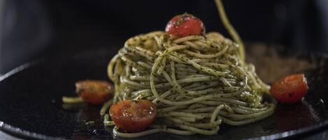 Un plato de espagueti con adorno de tomate.