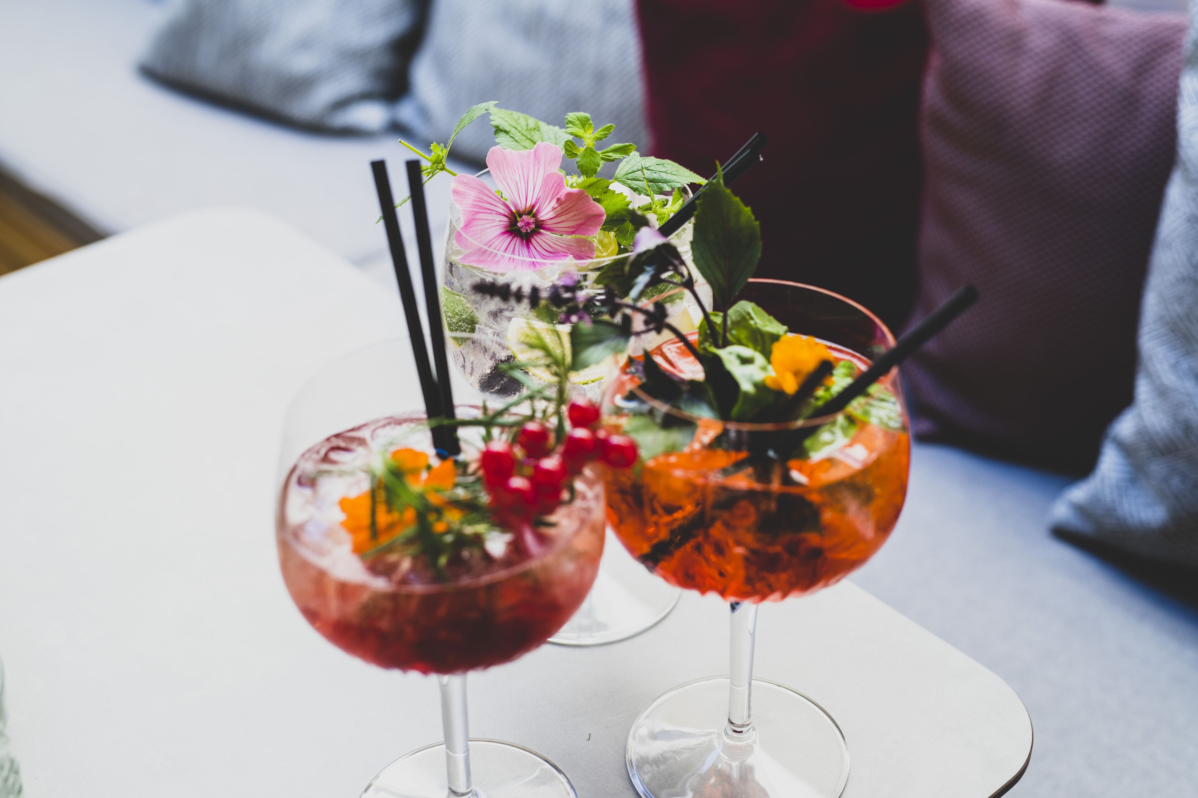 Due bicchieri da cocktail su un tavolo bianco, con sfondo sfocato.