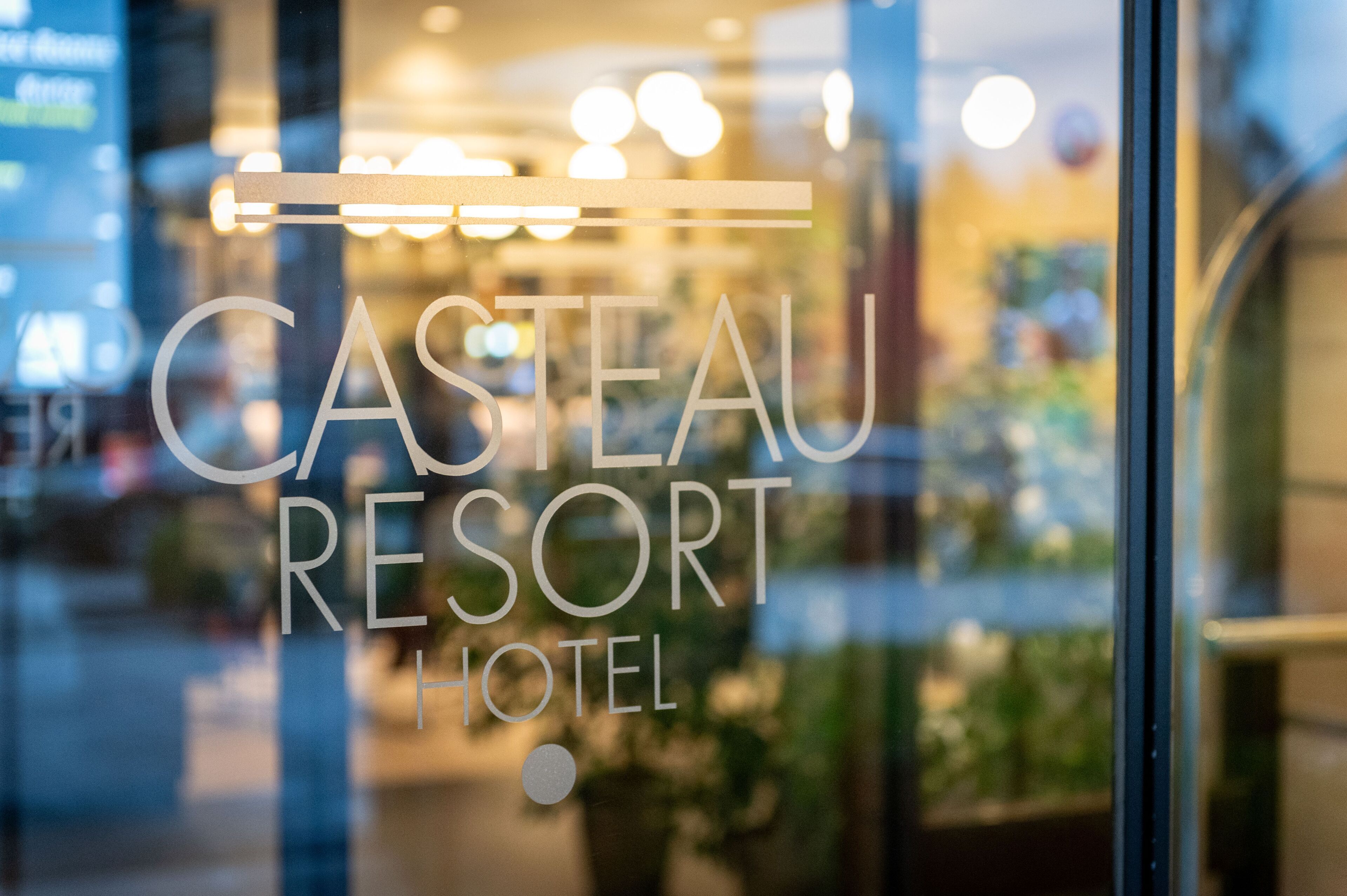 Das Schild des Casteau Resort Hotels mit unscharfem Hintergrund.