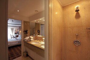 A hotel bathroom with two sinks, a mirror, a shower, and a toilet. - The Pand Hotel (Bruges)