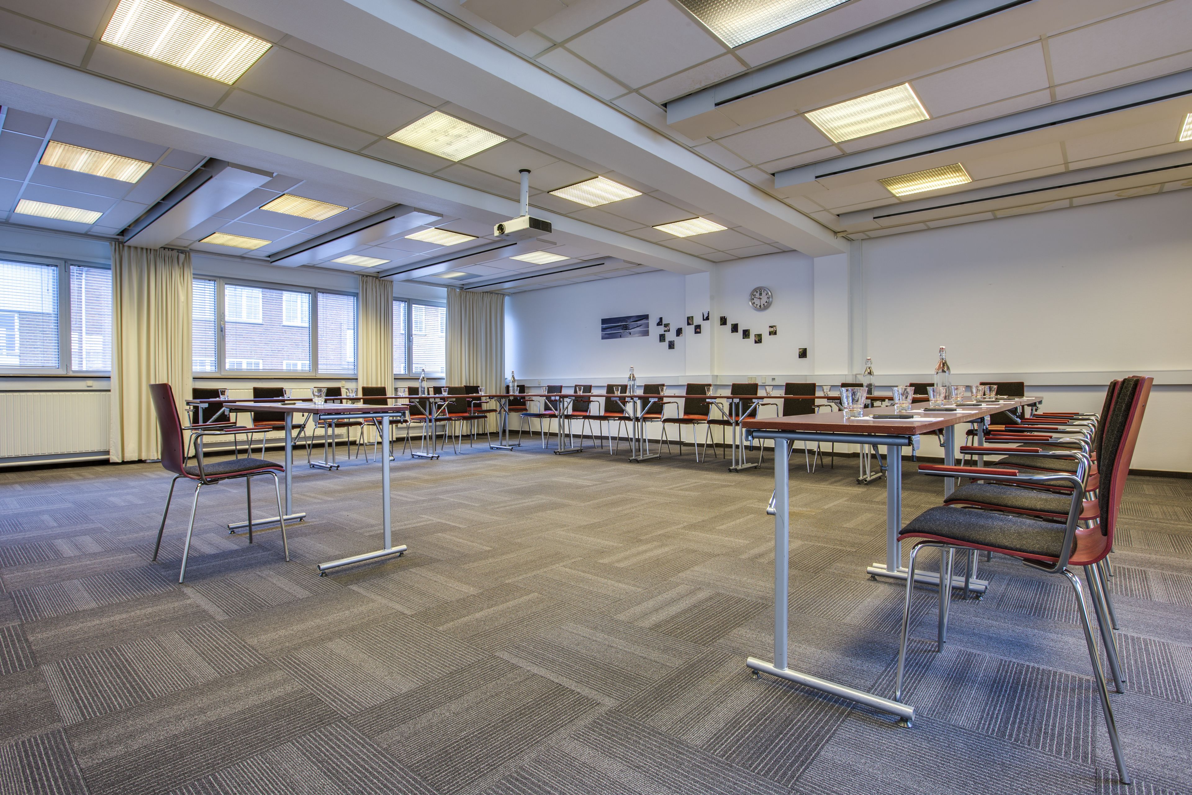 Une salle de conférence avec une longue table, des chaises et un projecteur.