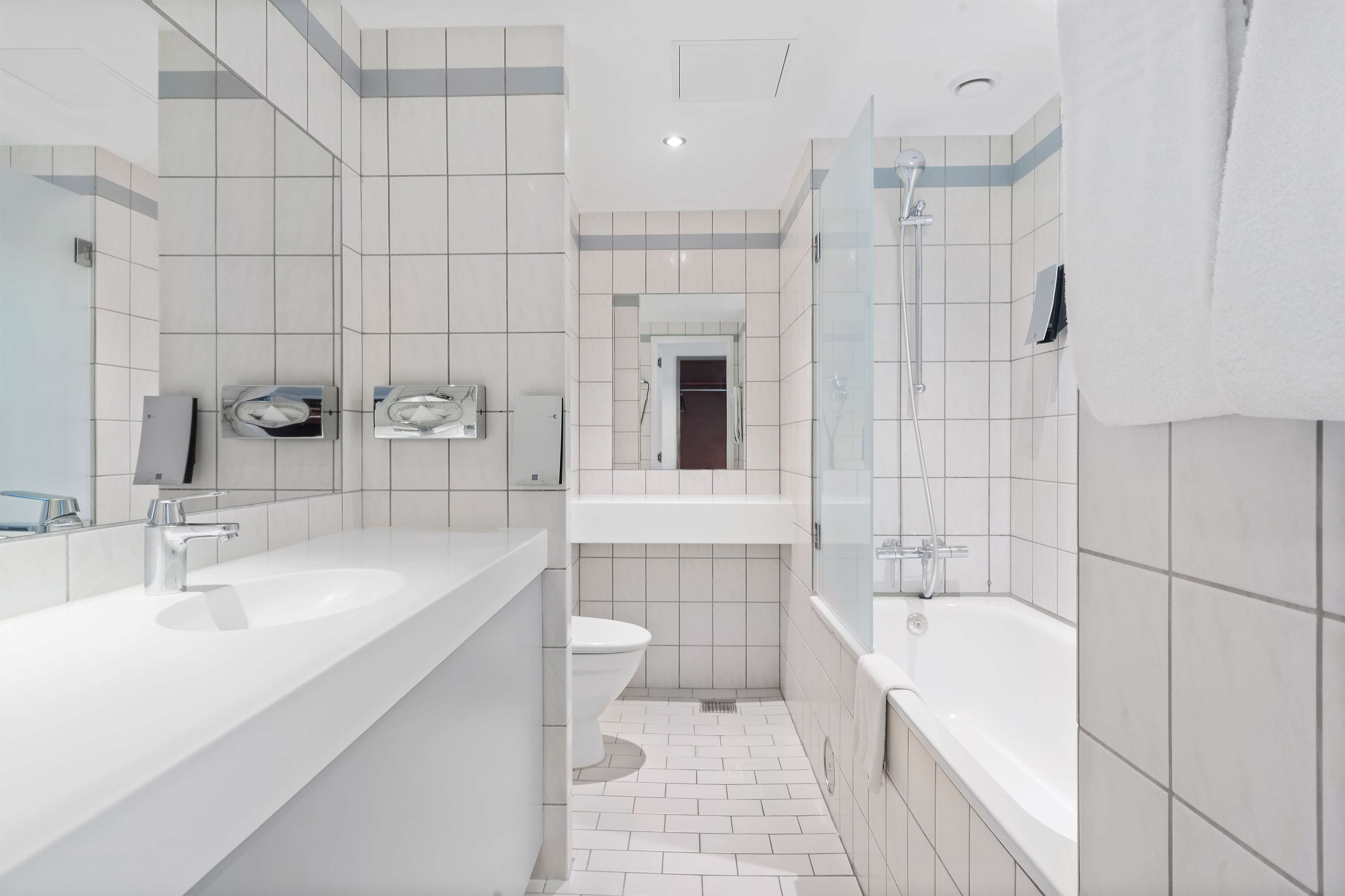 A modern bathroom with a large sink, toilet, and bathtub.