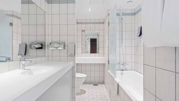 A modern bathroom with a large sink, toilet, and bathtub.