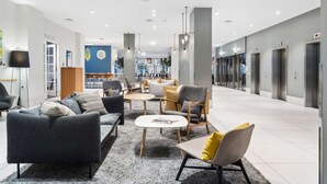 A modern lobby with seating areas, a reception desk, and a visible elevator. - Best Western Plus Airport Hotel Copenhagen (Kastrup)
