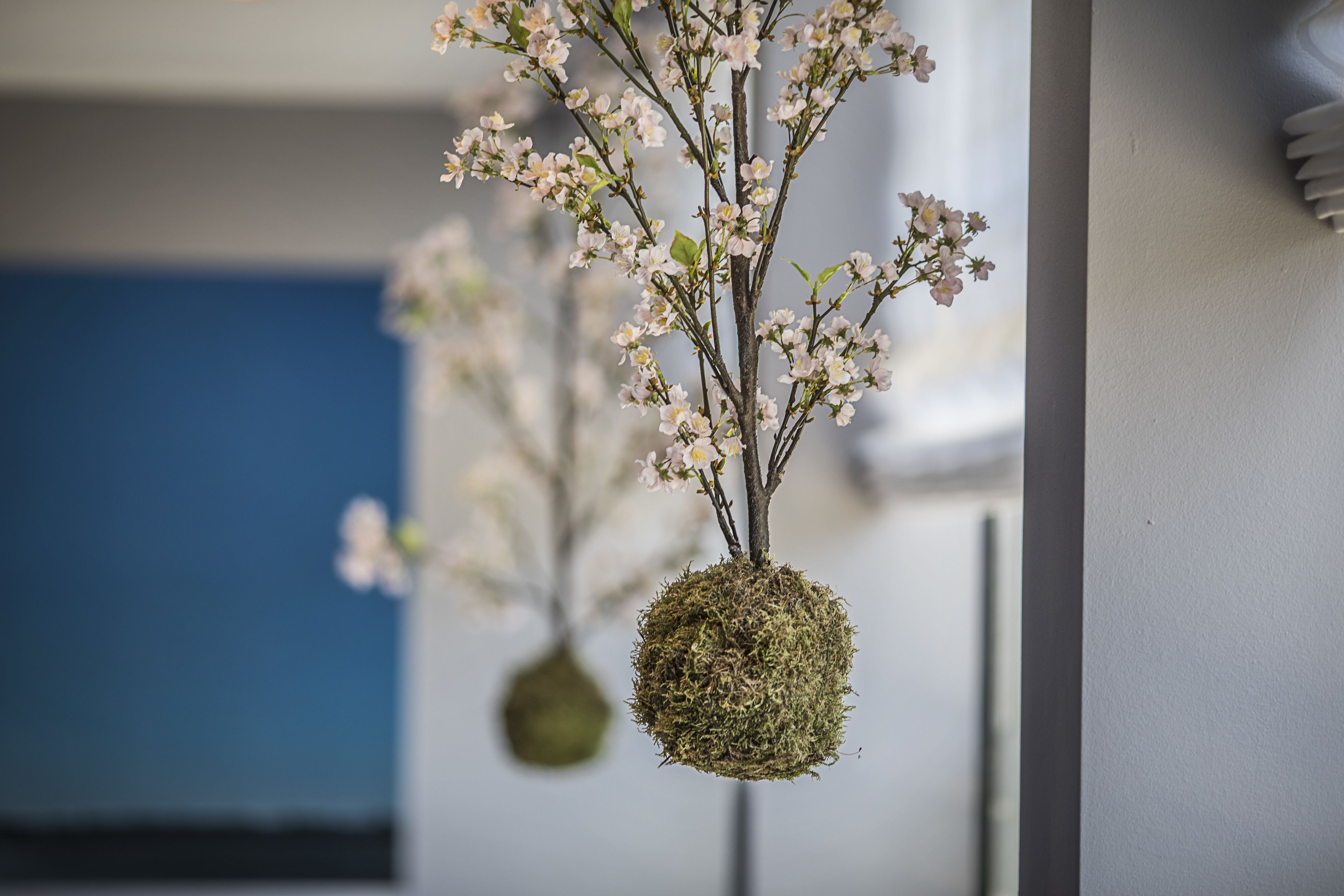 A hanging spherical object with branches and flowers.