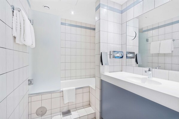 Un baño moderno con bañera, lavabo y espejo.