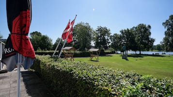 En park med flag, statue og et vandareal.