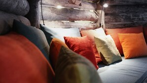Un lit confortable agrémenté de coussins colorés et d’une tête de lit en bois.