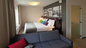 A hotel room with two beds, a sofa, and a wall-mounted artwork. - Original Sokos Hotel Koljonvirta (Iisalmi)