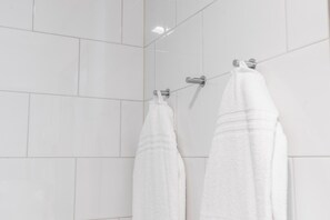 A bathroom with white tiled walls and two white towels hanging on a rack. - Original Sokos Hotel Koljonvirta (Iisalmi)