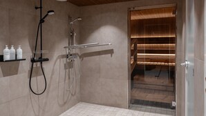 Une salle de bain moderne avec une douche, une porte en verre donnant sur un intérieur en bois et une étagère contenant des articles de toilette.