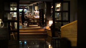 L'intérieur d'un restaurant, avec un bar, des tables et des chaises.