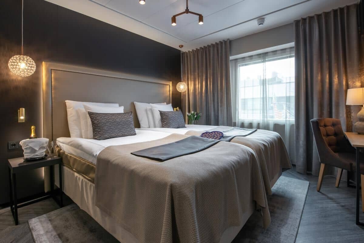Una habitación de hotel moderna con una cama grande, un escritorio y vistas a la ciudad.