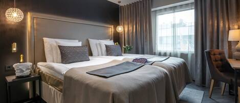 Een moderne hotelkamer met een groot bed, een bureau en uitzicht op de stad.