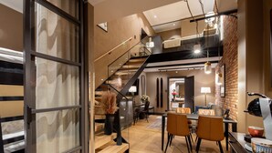 Un intérieur moderne comprenant un escalier, un coin repas et une cuisine.