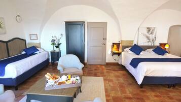 A hotel room with two beds, a dining table with breakfast, a chair, and a door.