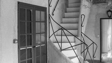 Una escalera con barandillas metálicas que conduce a una puerta con paneles de vidrio.