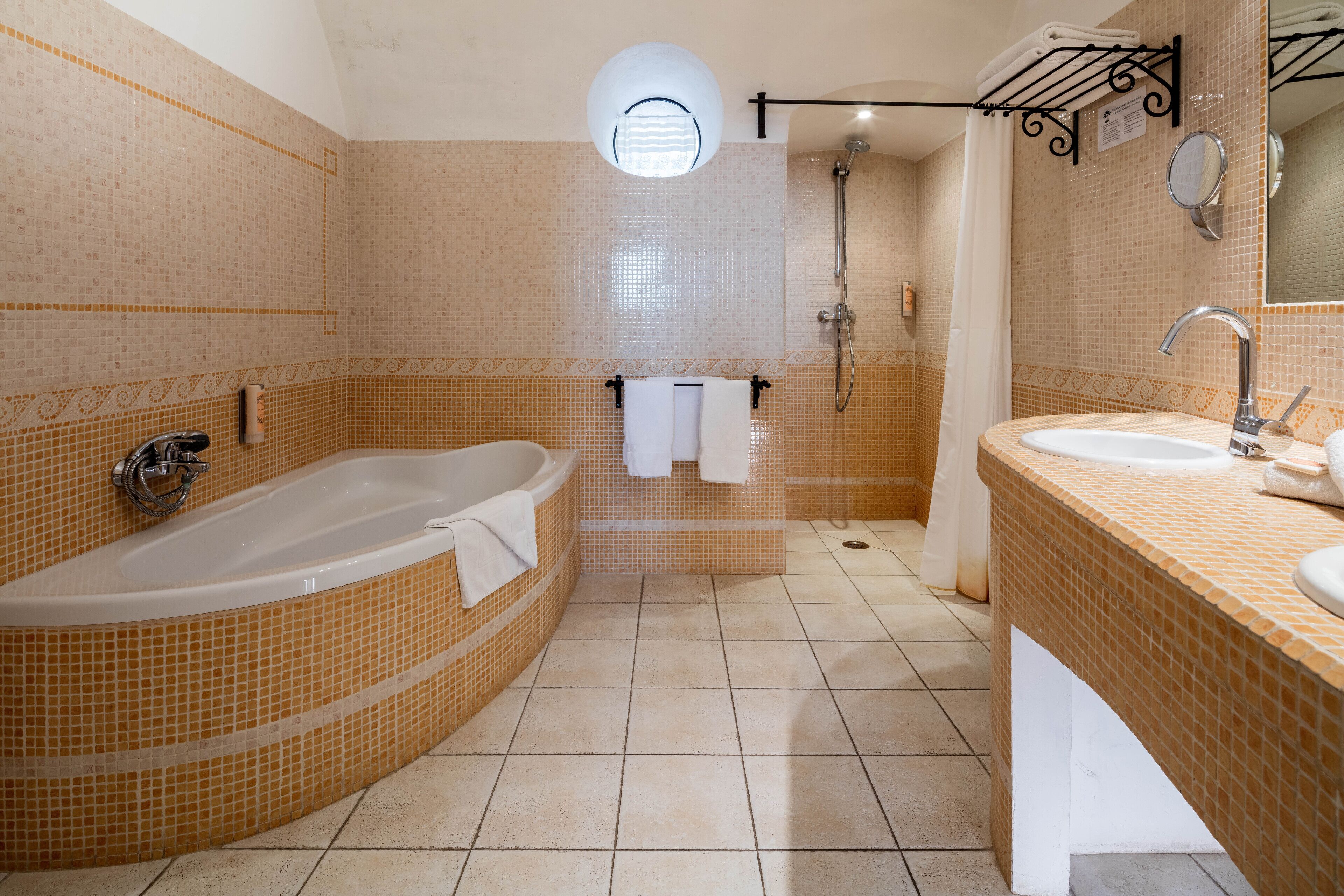 Une salle de bain avec une grande baignoire, une douche et un lavabo.