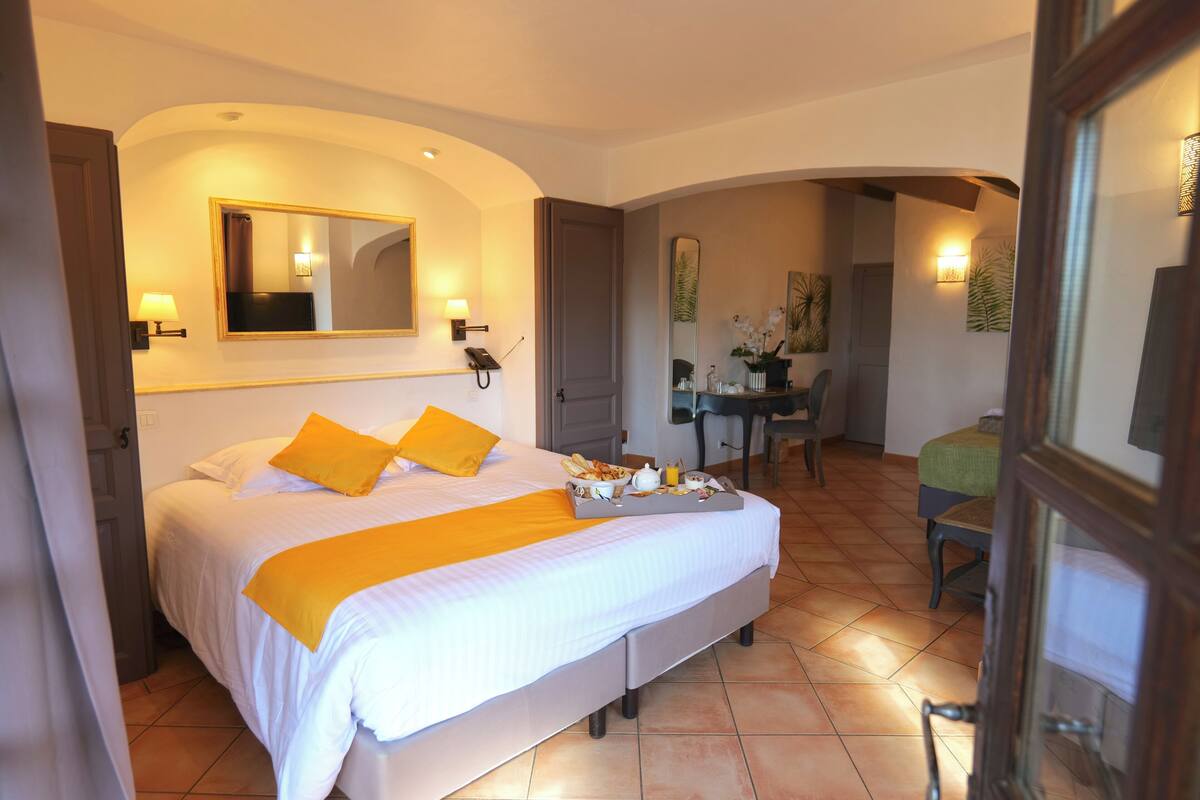 A hotel room with a bed, a desk, and a chair.