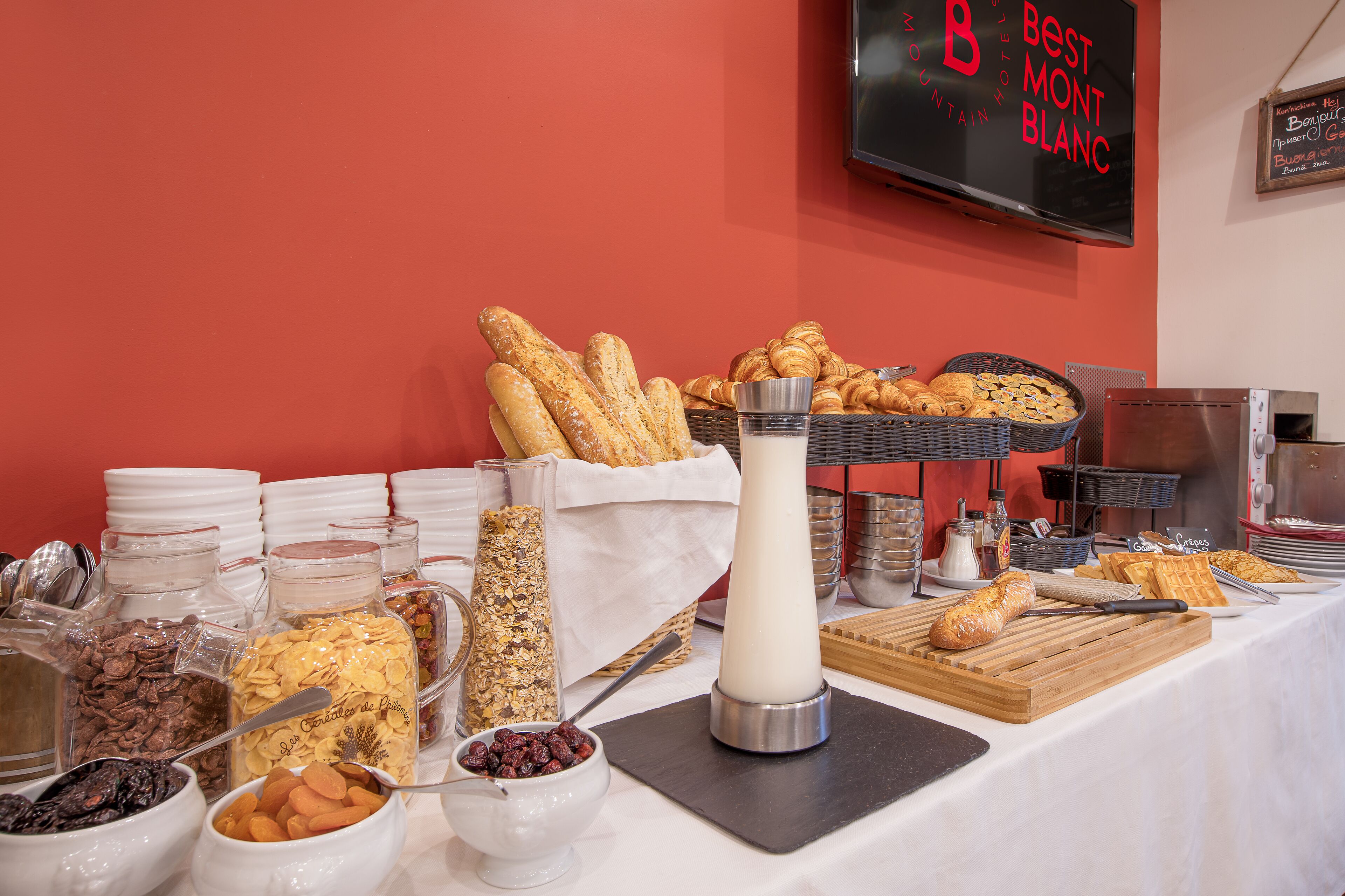A breakfast buffet with various food items and a milk dispenser.