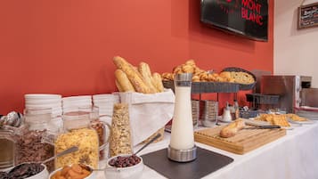 A breakfast buffet with various food items and a milk dispenser.