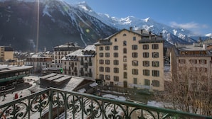 Un pueblo con montañas nevadas al fondo, edificios de arquitectura tradicional y un cielo despejado.