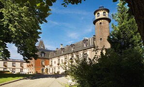 Experience the grandeur of this historic building, surrounded by lush greenery and adorned with decorative elements.
