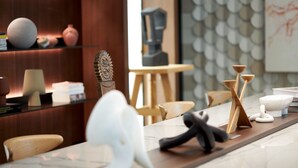 A modern kitchen with a marble countertop, wooden chairs, and various kitchen utensils. - L'Esquisse Hotel & Spa Colmar - MGallery Collection (Colmar)