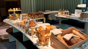 Un buffet proposant divers plats et un ordinateur portable posé sur une table.