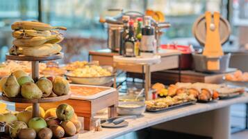 A buffet with fruits and pastries.