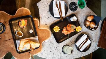 Una mesa de comedor con diversas opciones de comida, como salmón, pan y bebidas.