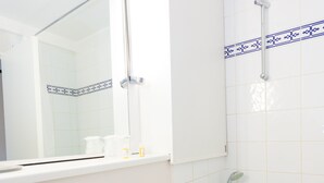 A bathroom with a white sink, a mirror, and a shower. - Hôtel Inn Design Grenoble Eybens Parc des Exposition (Eybens)