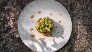 Un plato redondo y blanco con un alimento sobre una superficie texturizada.