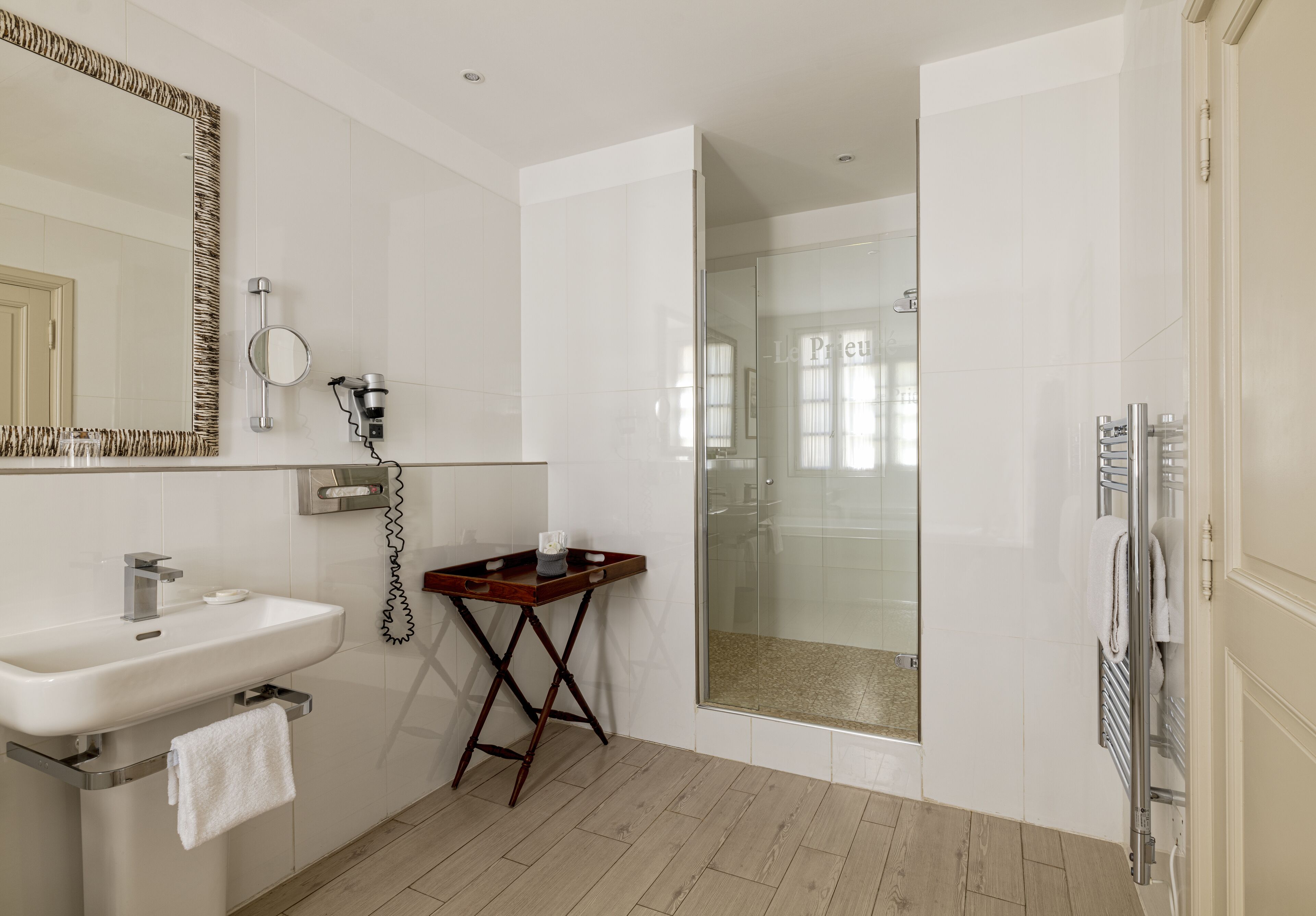 Une salle de bain moderne avec un lavabo, un miroir et une douche.