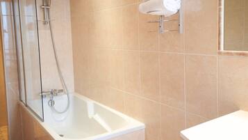 A bathroom with a glass-enclosed shower, a white bathtub, and a towel rack with two white towels.