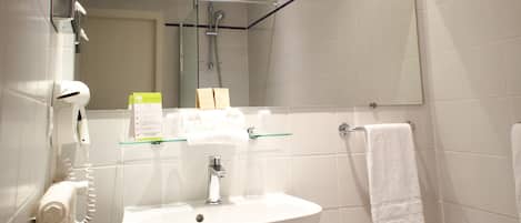 A bathroom with a sink, mirror, towel rack, and a hairdryer.