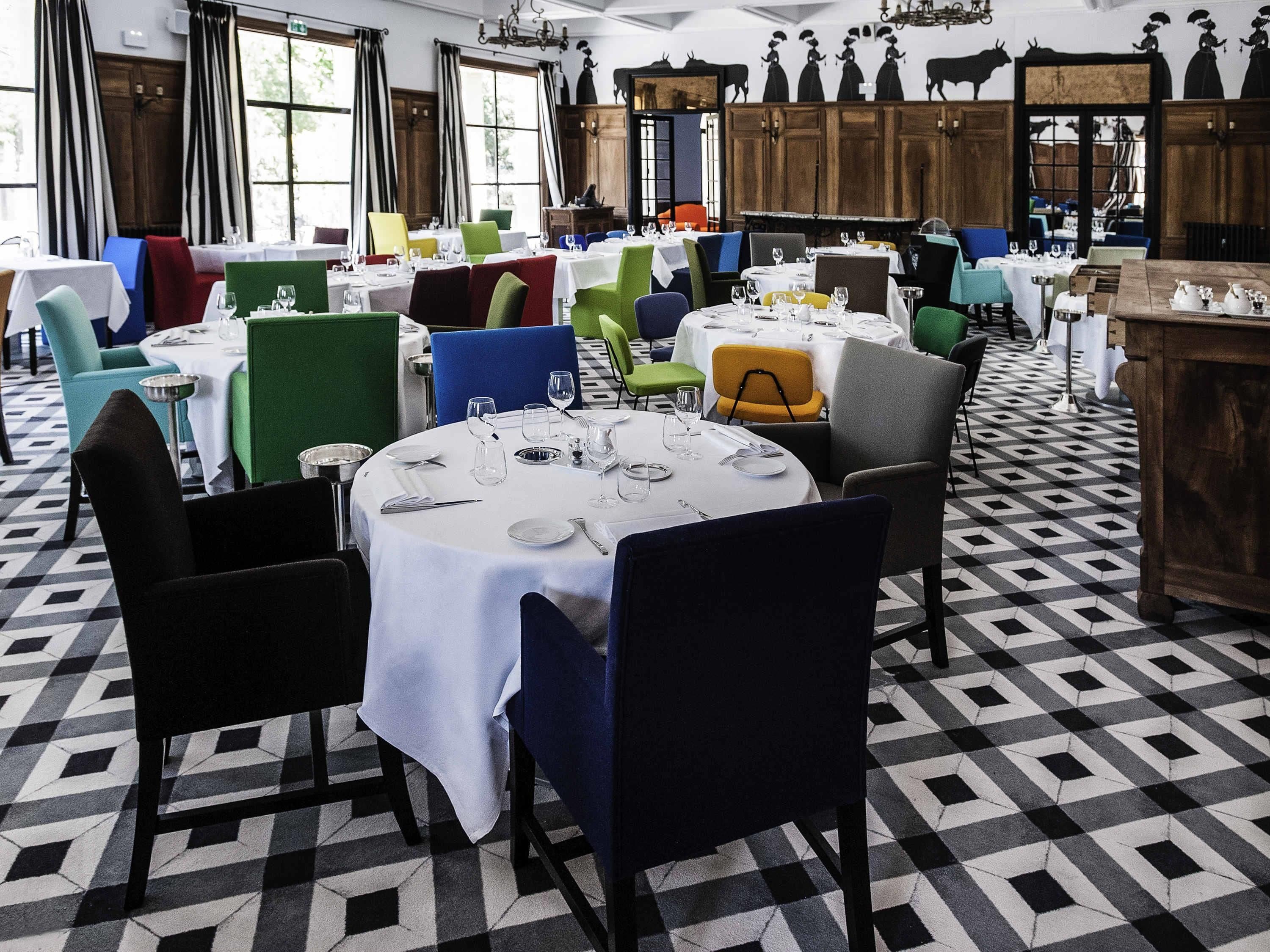 A dining area with round tables, chairs, and a patterned floor.
