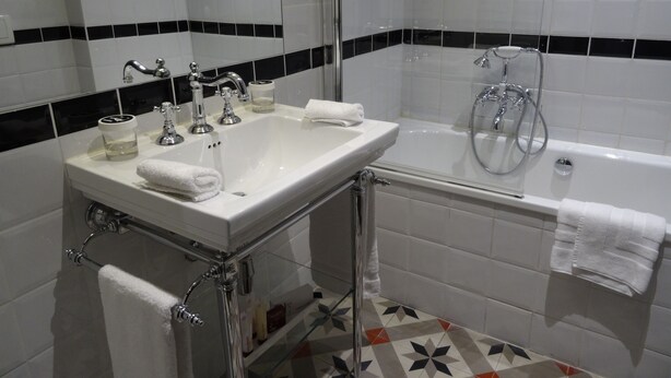 Un baño con un lavabo blanco, una bañera y una ducha.