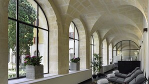 A hotel lobby with arched ceilings, large windows, and a seating area with towels. - Jules César Hotel & Spa Arles - MGallery Collection (Arles)