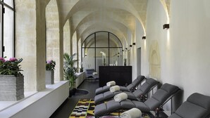 A spa area with reclining chairs, a massage table, and potted plants. - Jules César Hotel & Spa Arles - MGallery Collection (Arles)