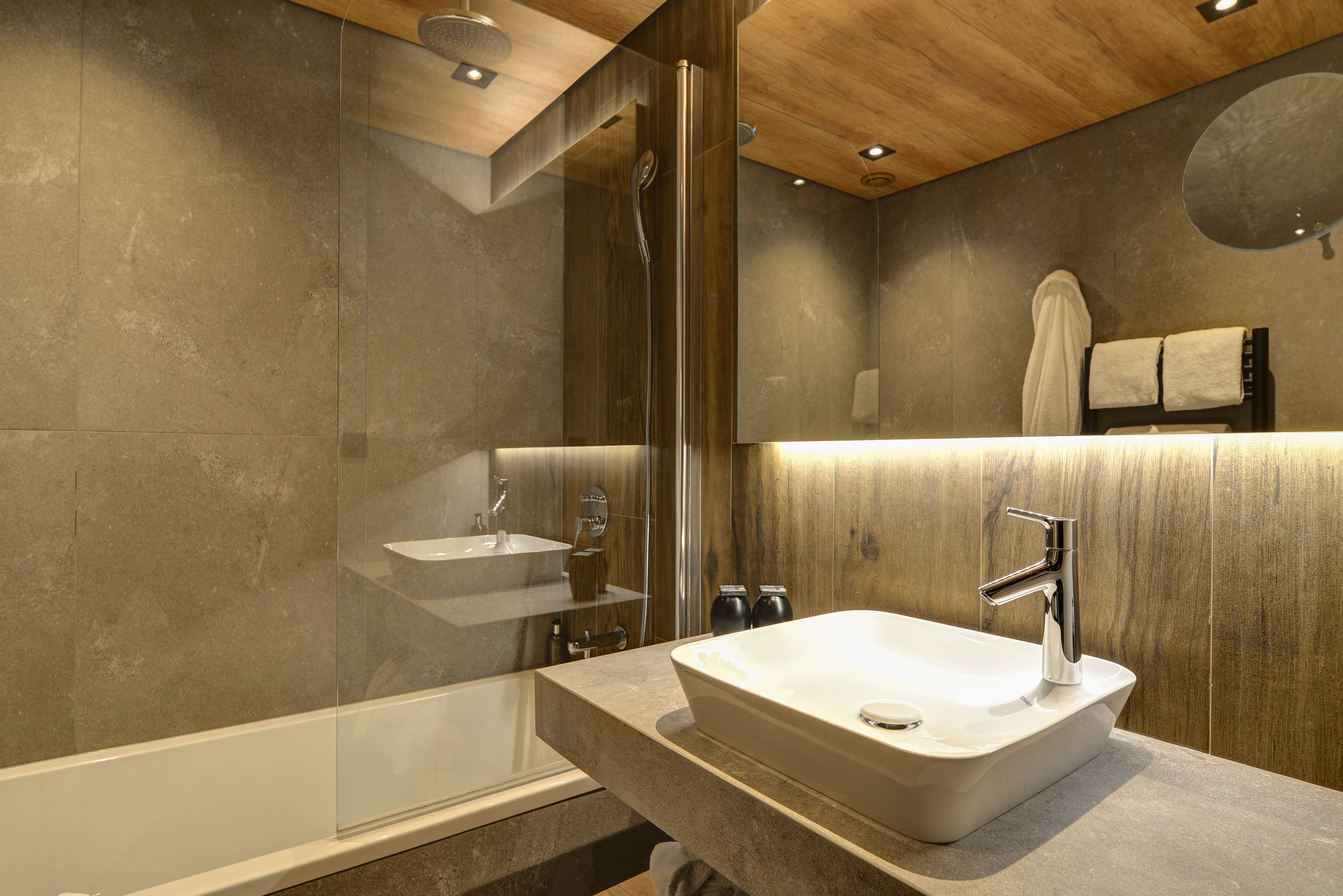 Un baño moderno con una bañera grande, un lavamanos independiente y una ducha.