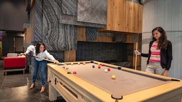 A pool table in a modern room with wooden and marble accents.