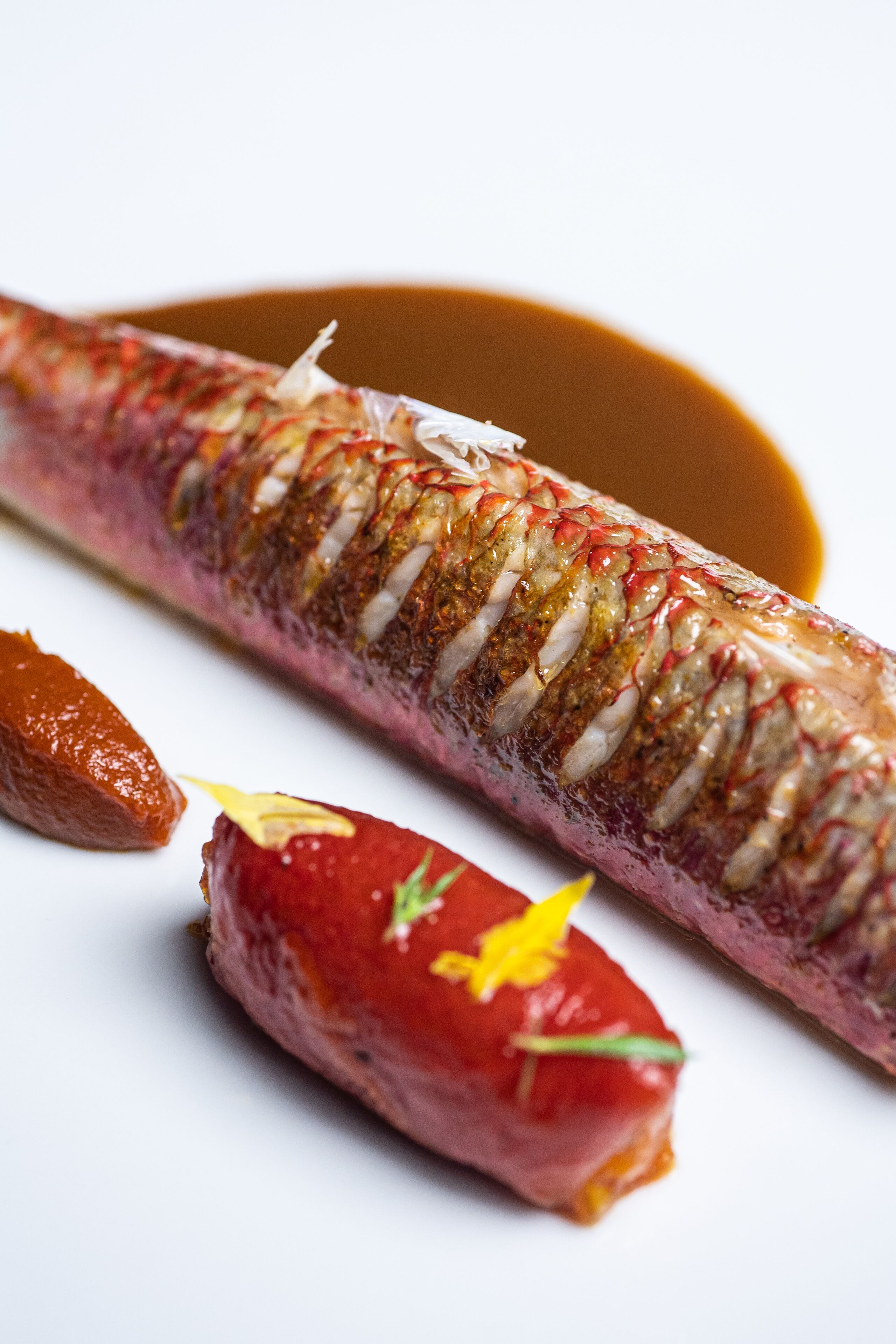 Un plat de poisson accompagné d’une sauce et de garnitures.