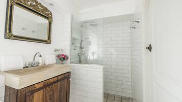 Une salle de bain avec un meuble-lavabo en bois, un grand miroir et une douche à parois de verre.